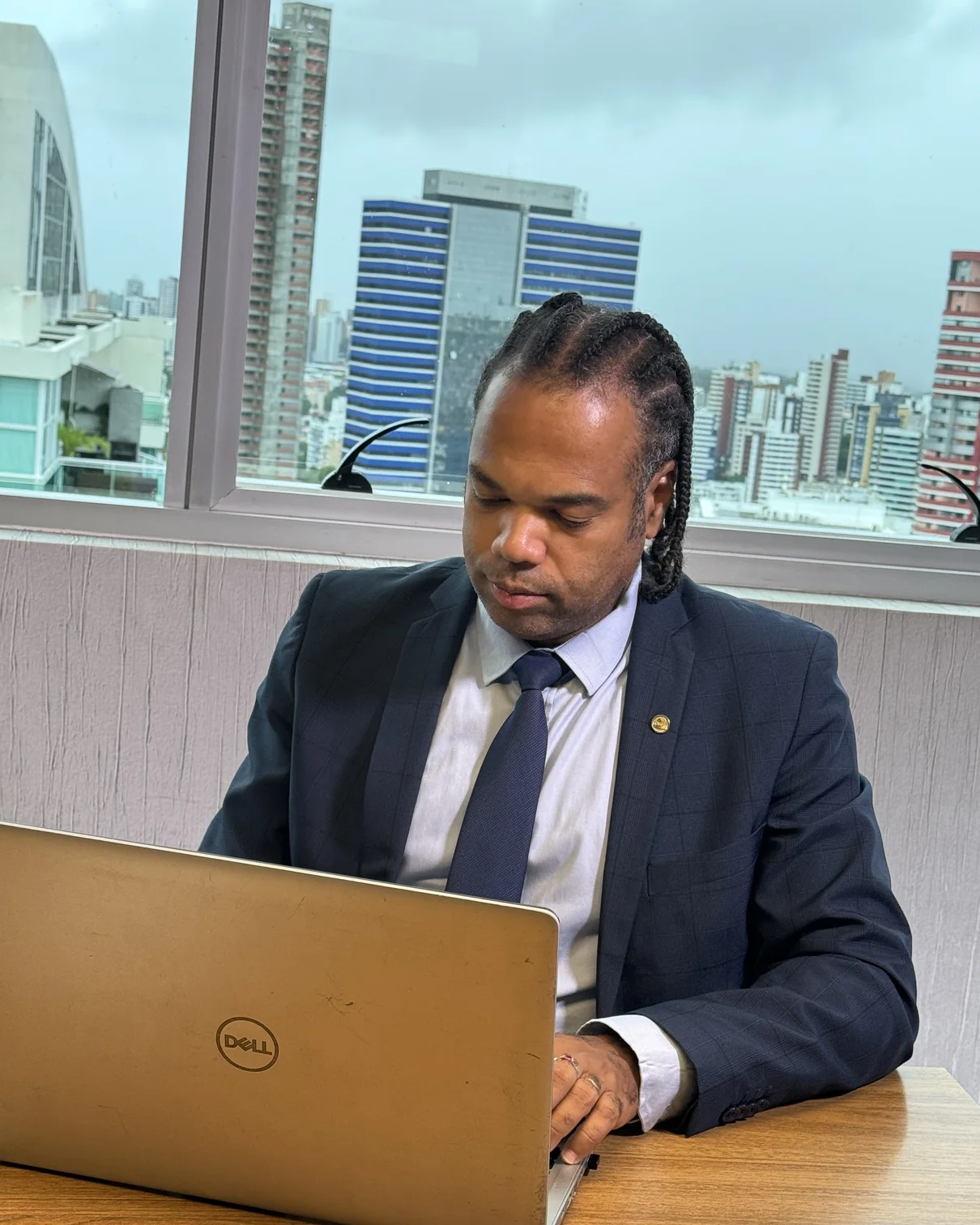 André Luis Dedeko trabalhando no escritório da Ampla Contabilidade, com Salvador ao fundo