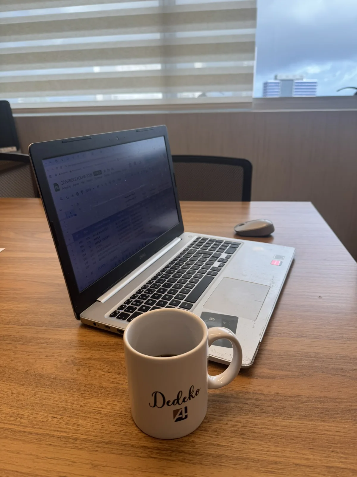 Mesa de trabalho na Ampla Contabilidade, com planilha de folha de pagamento na tela